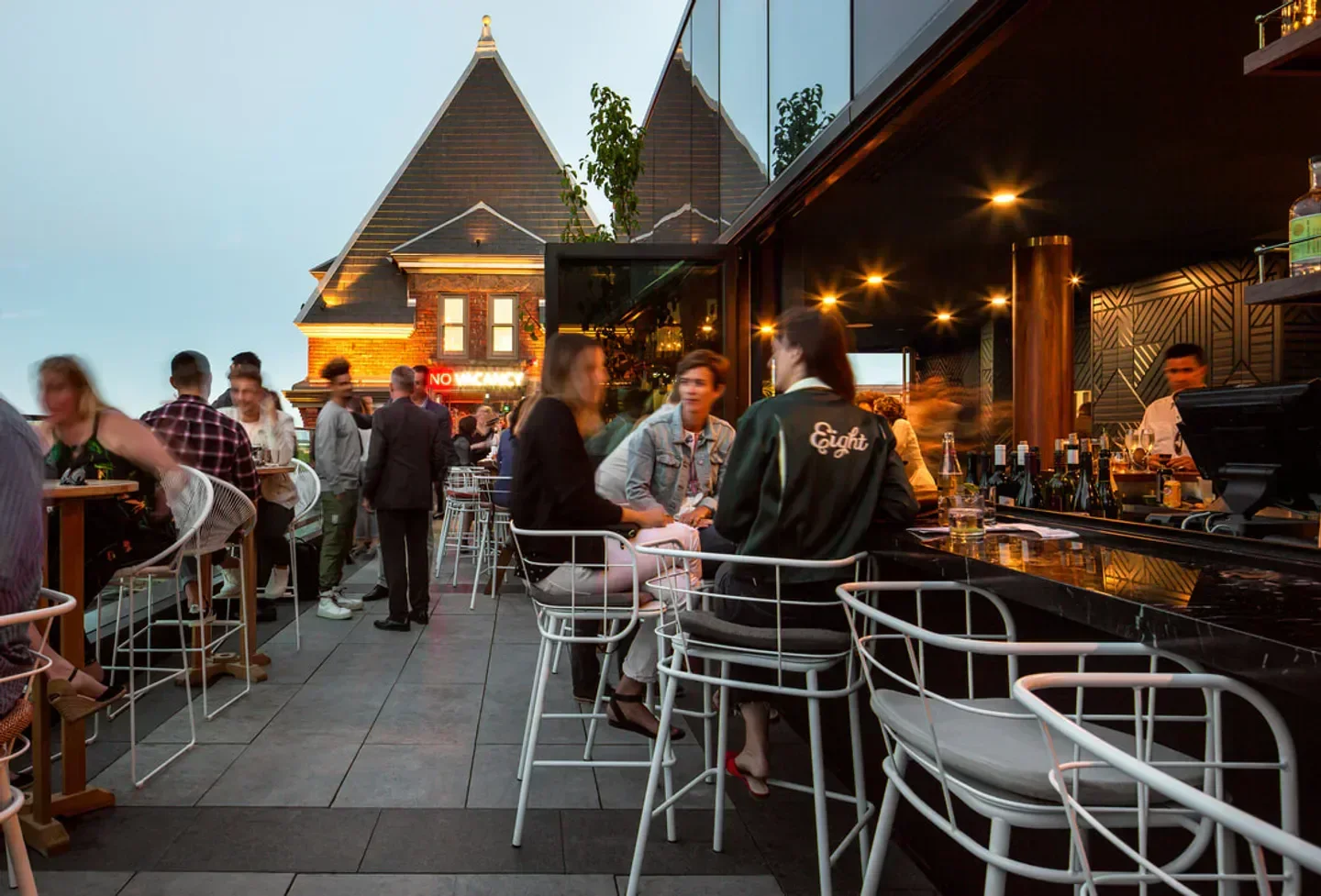 Evening scene at The Broadview Hotel Rooftop bar in Toronto with people gathered.