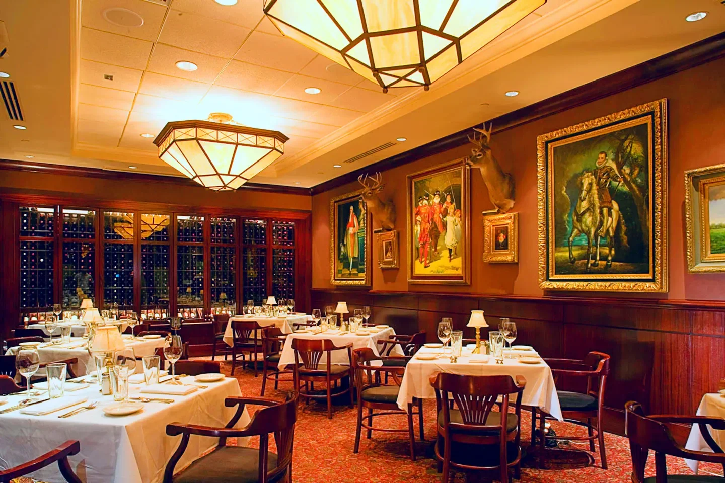 Interior dining area at The Capital Grille - Houston, with paintings and elegant tables in Houston.