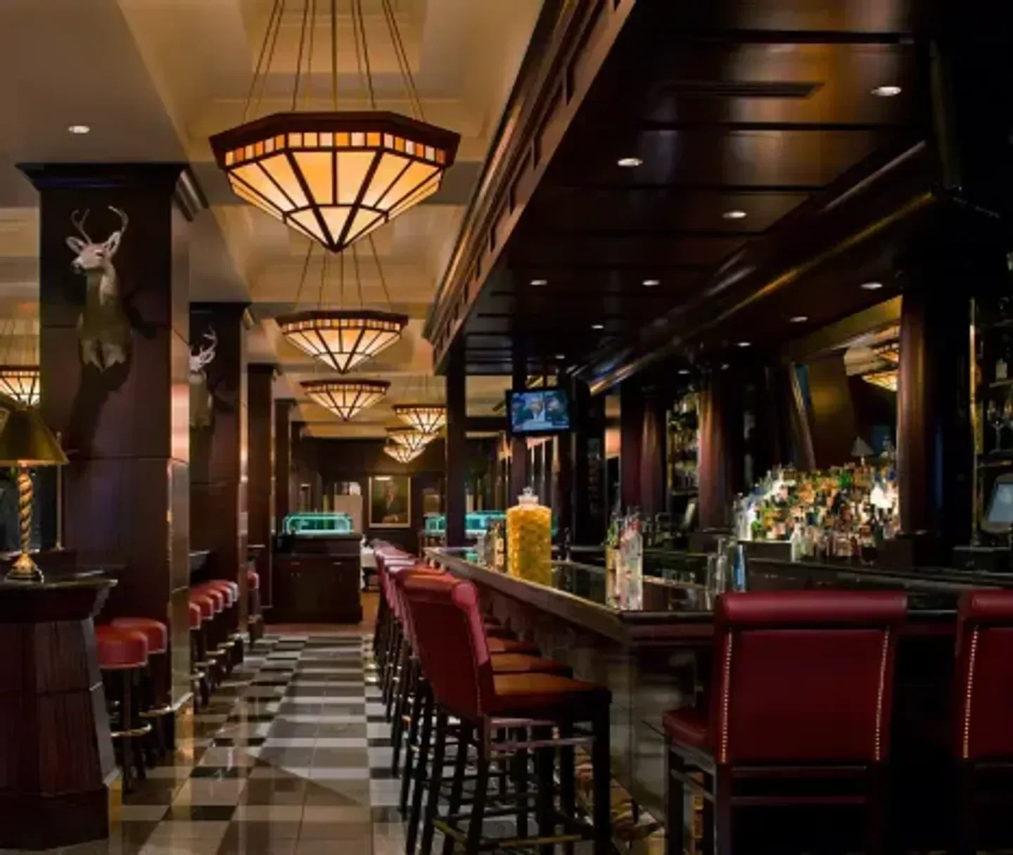 Elegant bar at The Capital Grille - Seattle, with chandeliers and red seating in Seattle.