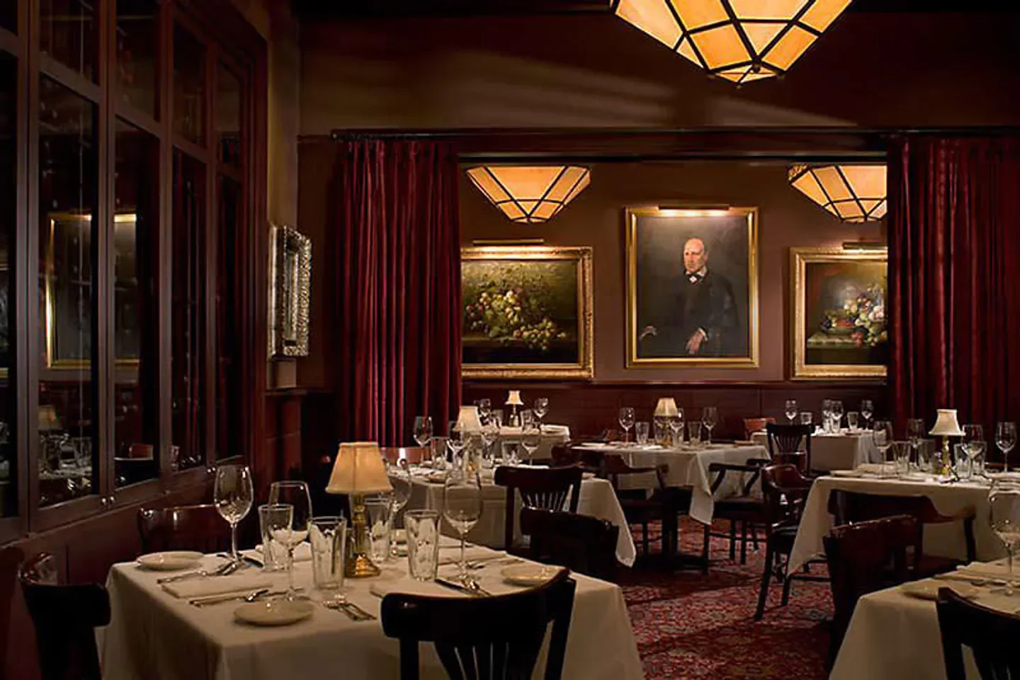 Elegant dining room at The Capital Grille in Washington D.C., with art and tables set.