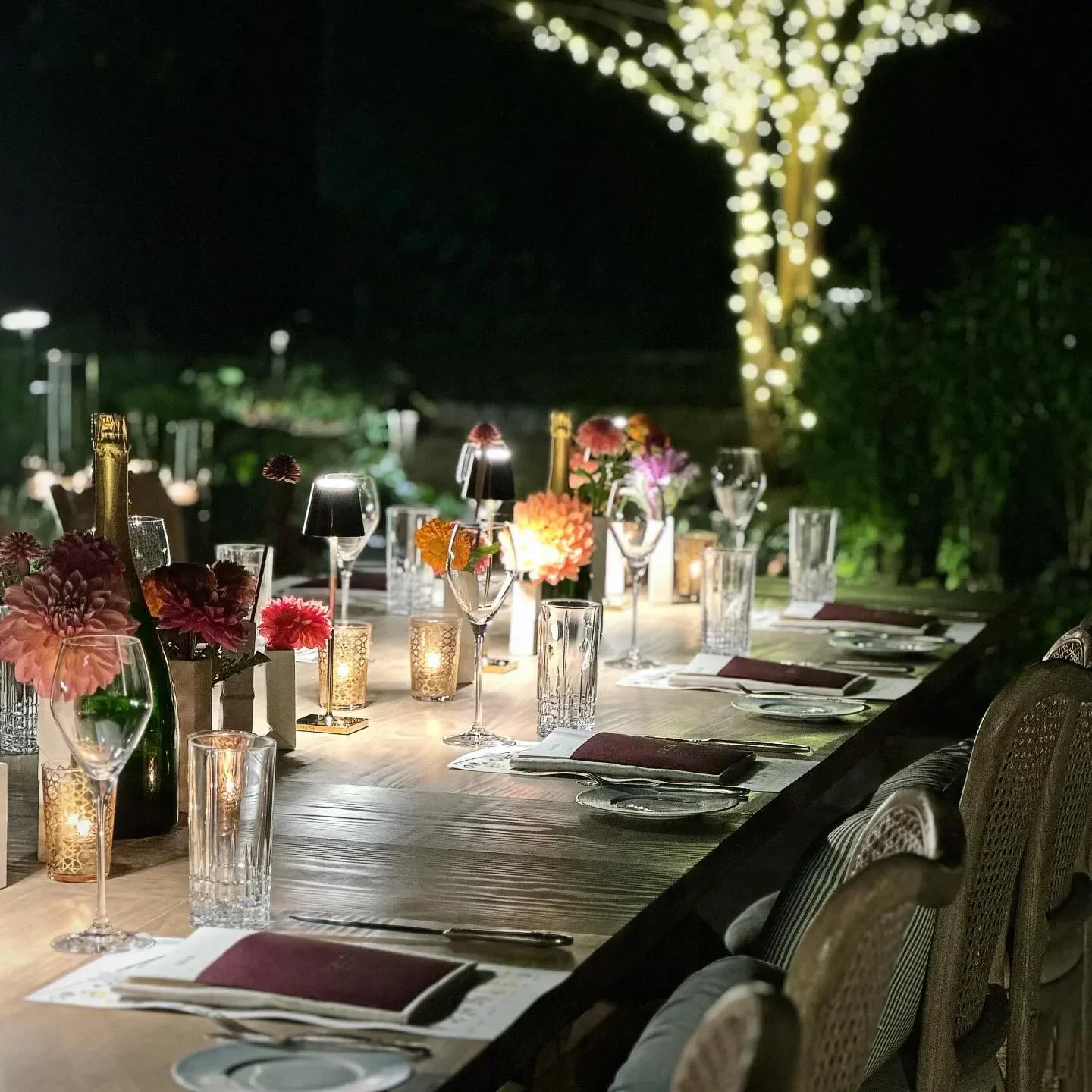 Romantic outdoor dining at THE CHASTAIN restaurant in Atlanta with floral arrangements.