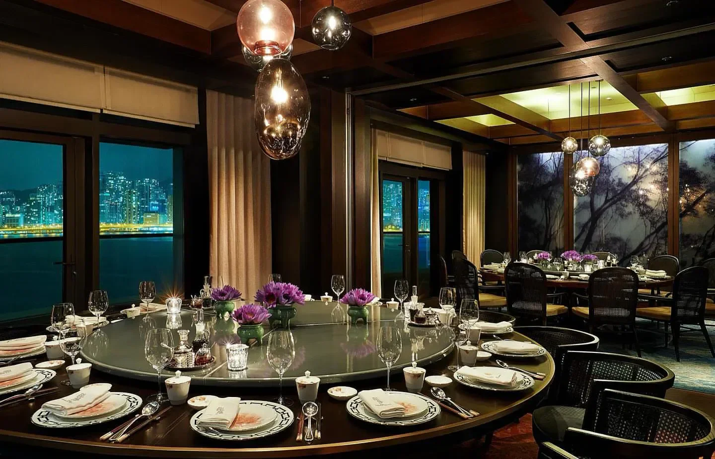 Elegant dining room at The Legacy House in Hong Kong with city views at night.