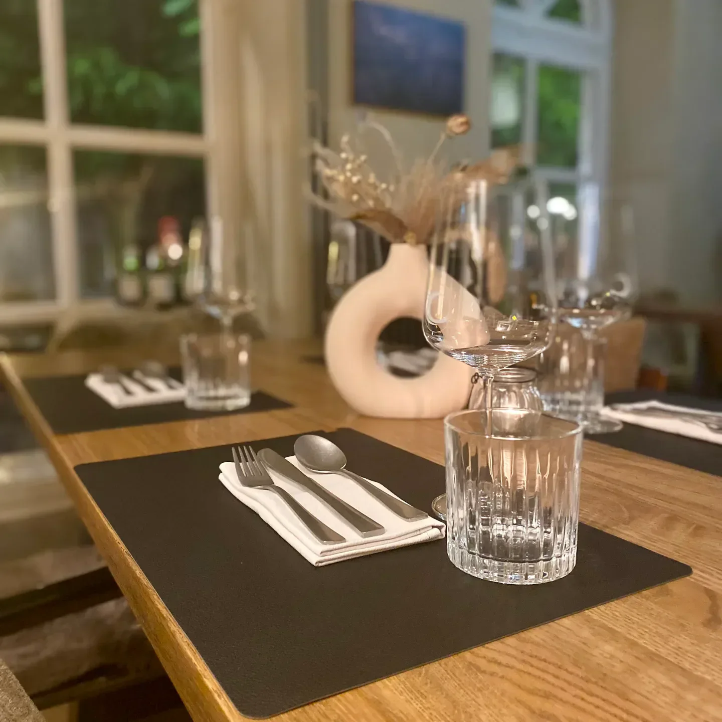 Table setting at THE LISBETH restaurant in Hamburg, featuring elegant glassware and decor.