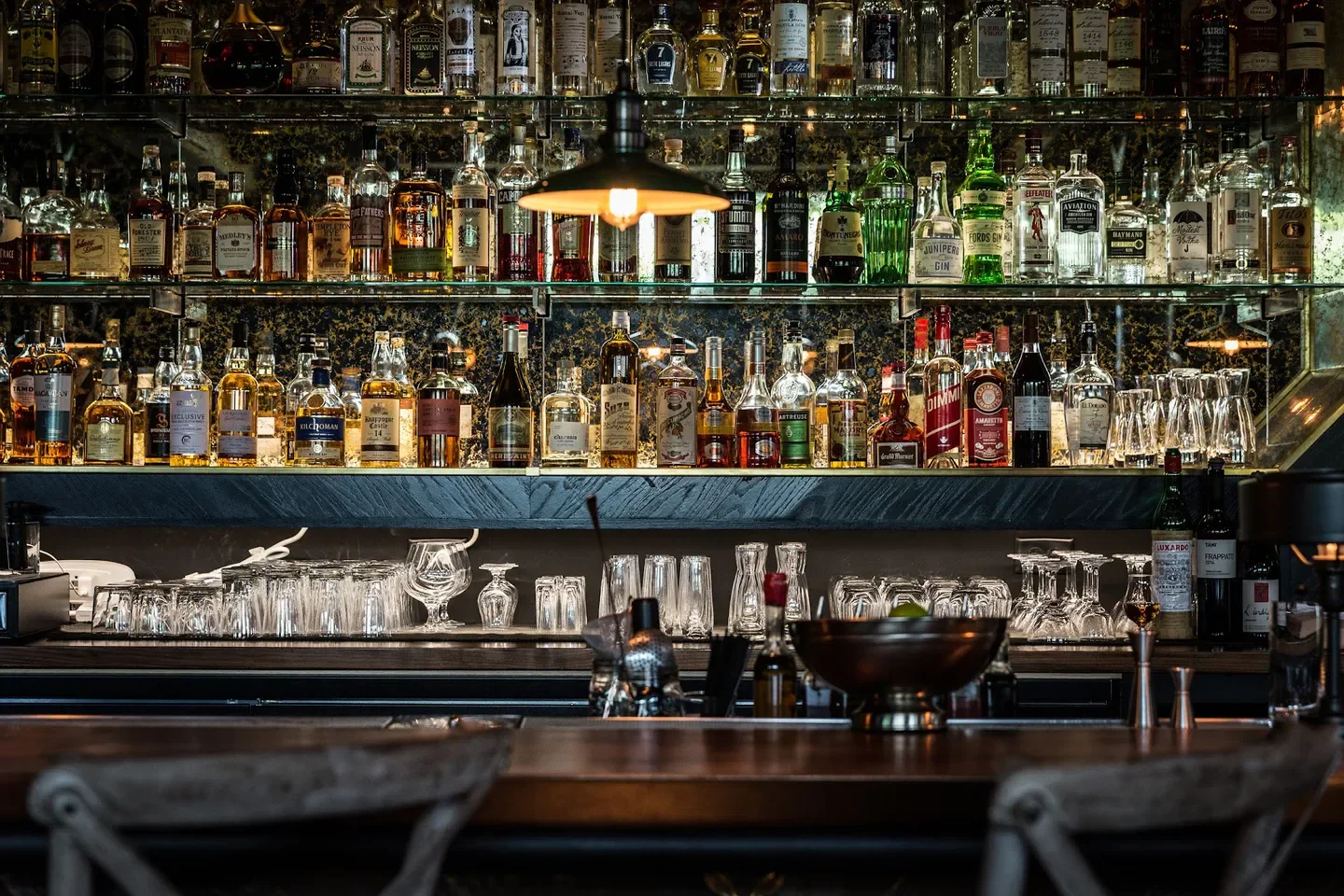 Well-stocked bar at The Loyalist restaurant in Chicago, with various bottles and glasses.