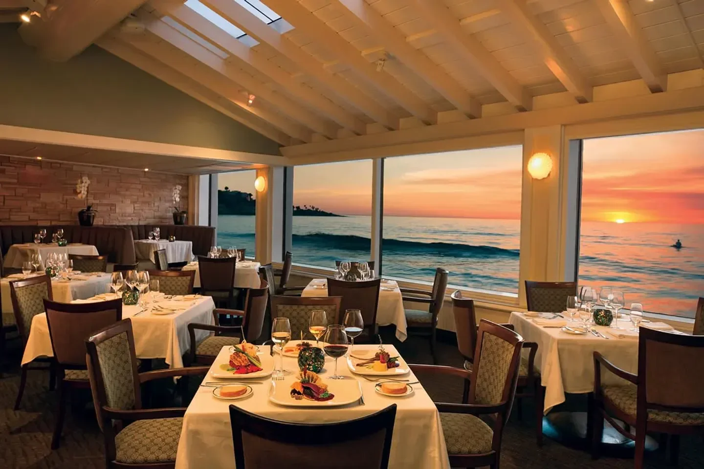 Dining room at The Marine Room in San Diego, overlooking a beautiful ocean sunset.