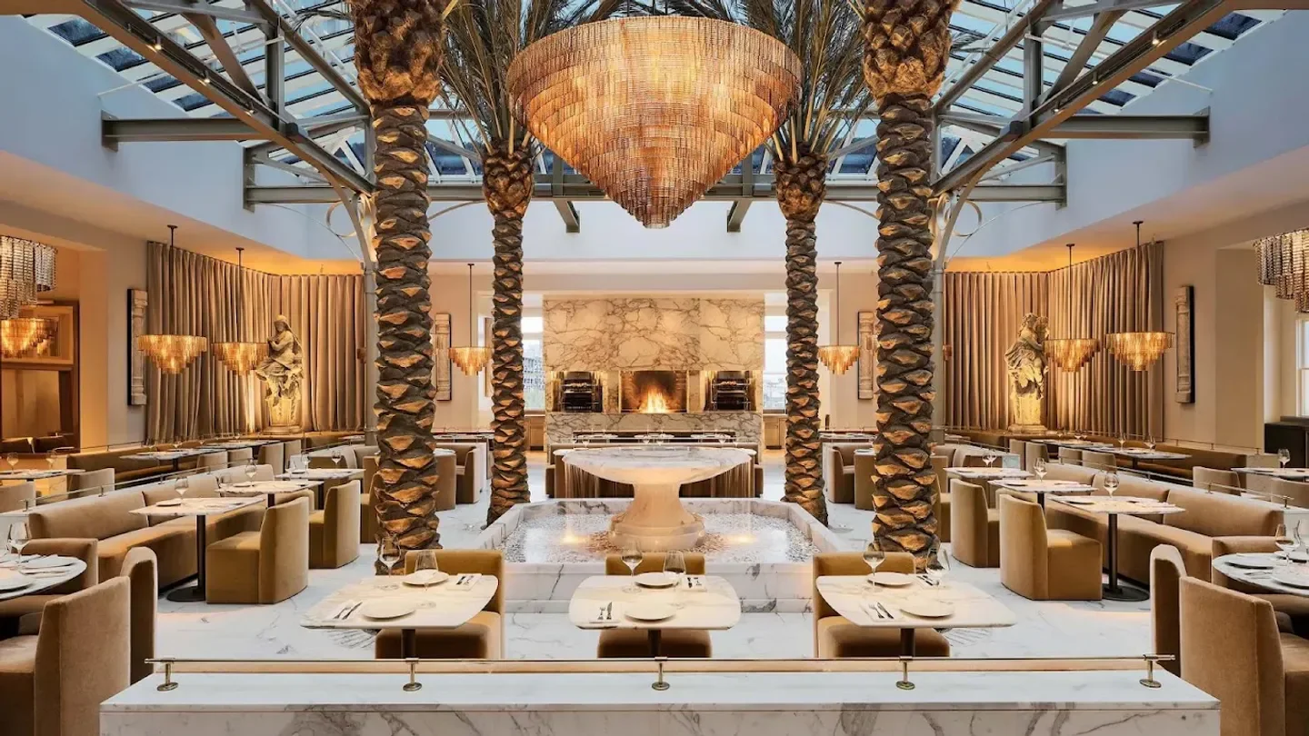 Elegant interior of The Palm Court at RH San Francisco, with palm trees and a water feature.