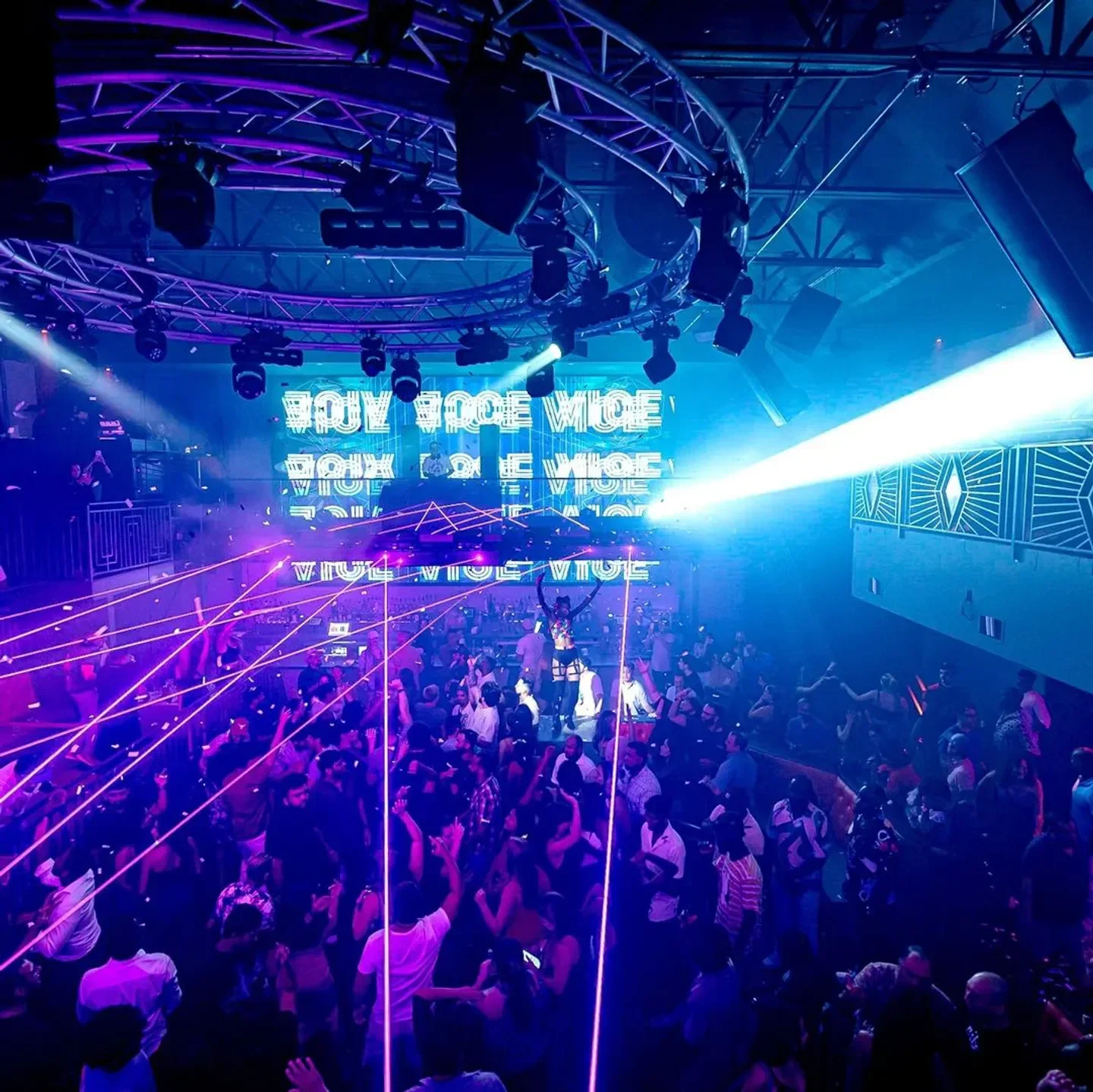 Energetic crowd at The Rose Room nightclub in Austin, with neon lights and laser beams.