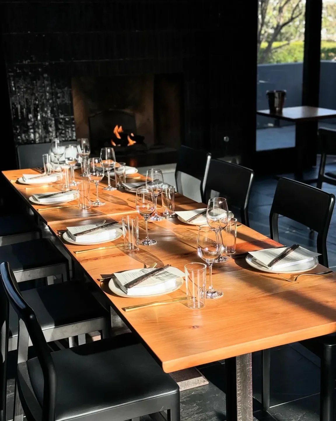 Dining table set at The Slanted Door in San Francisco, with a fireplace in background.
