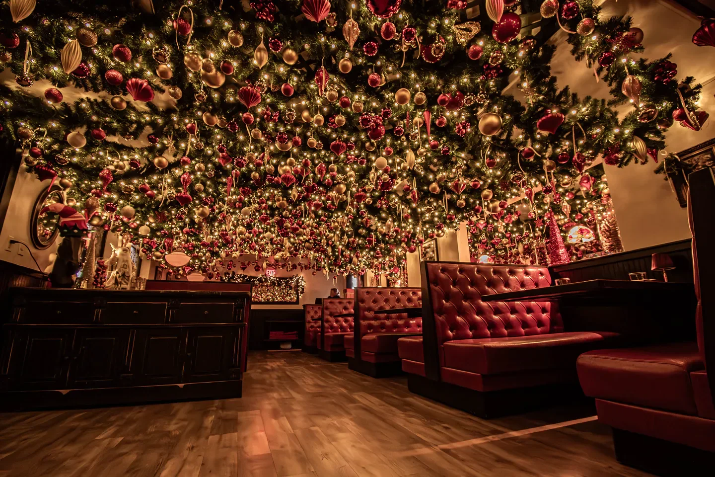 Festive Christmas decor at The Venetian restaurant in Boston with red booths and lights.