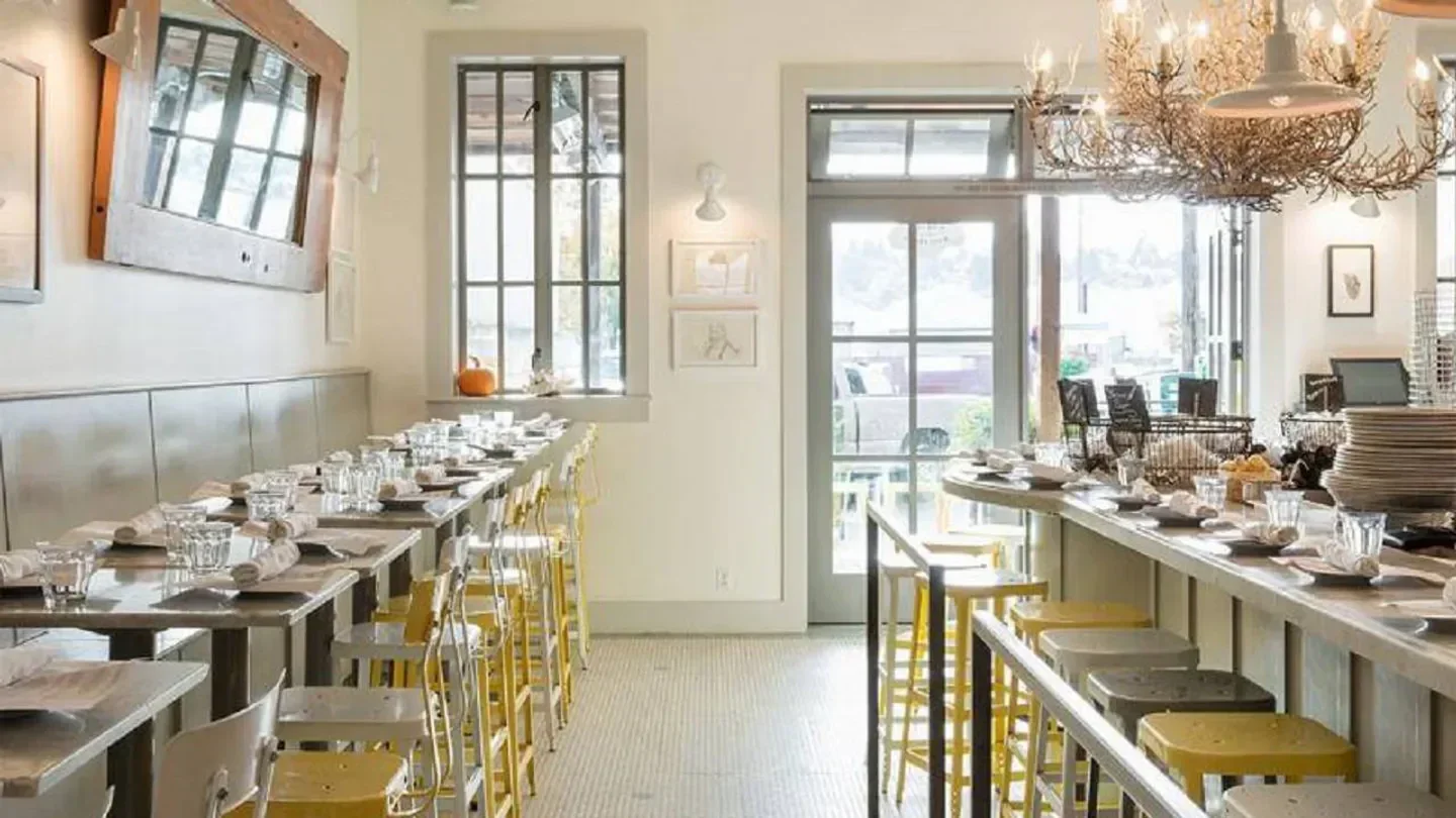 Interior of The Walrus and Carpenter restaurant in Seattle, with tables and bar seating.