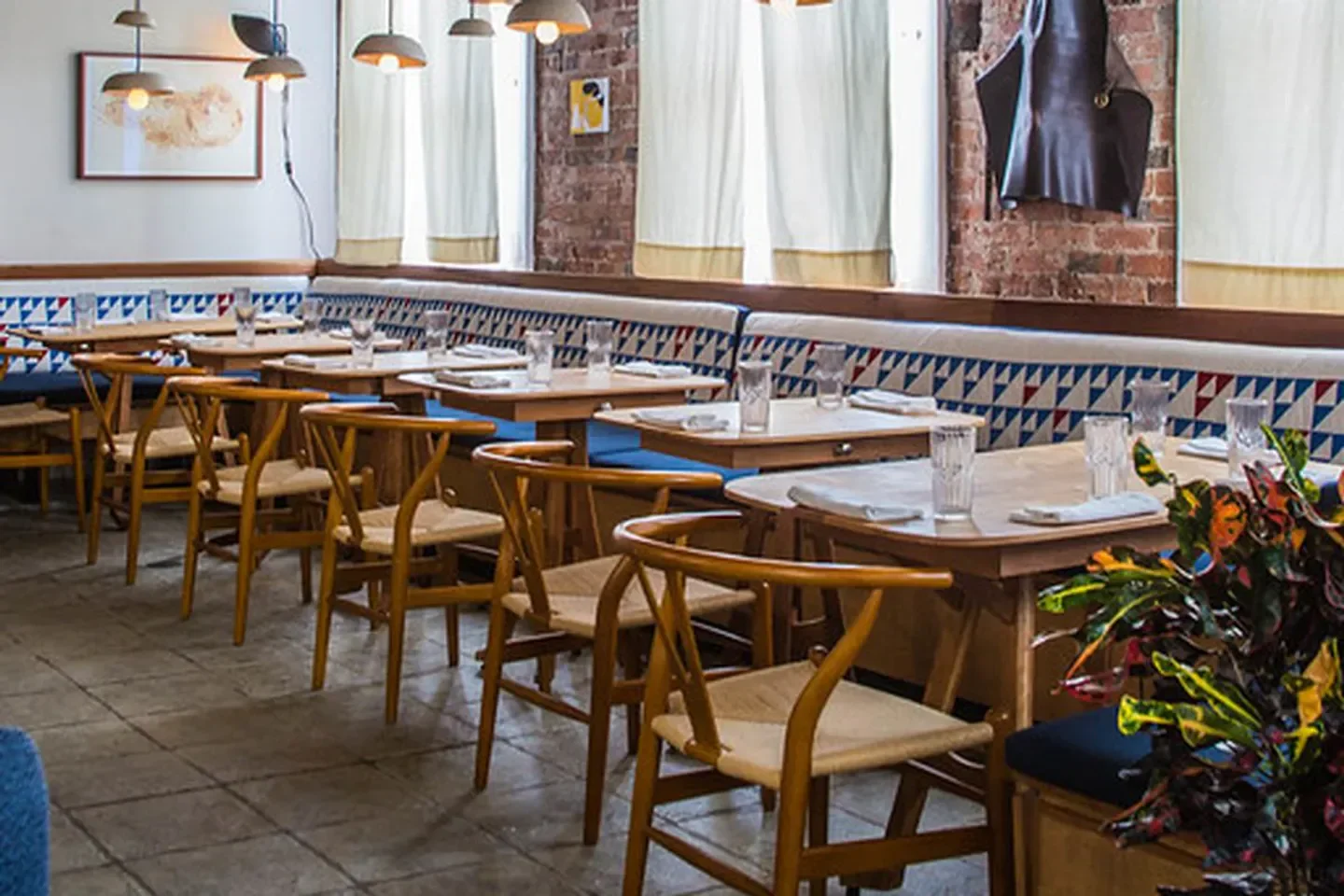 Cozy dining area at Theodore Rex restaurant in Houston with wooden chairs and tables.