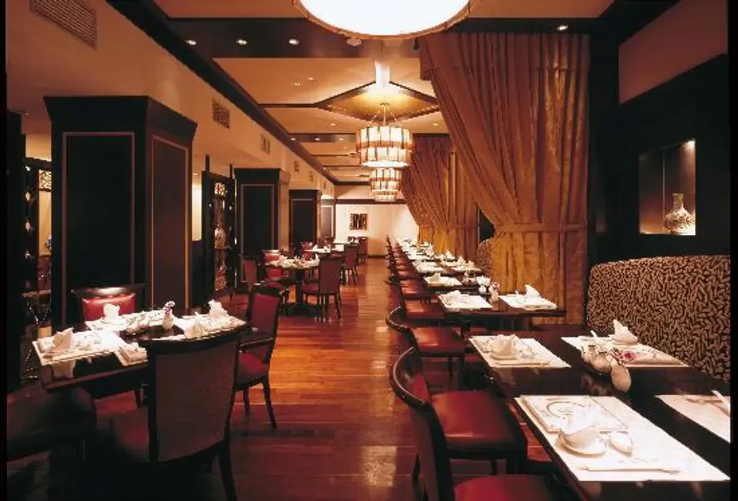 Elegant dining room interior at Toh-Ka-Lin restaurant in Tokyo, with warm lighting and tables.