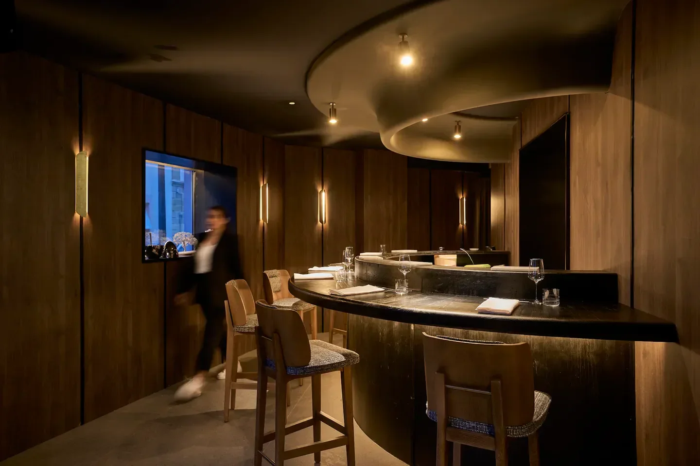Interior of Toki in Madrid, showcasing its stylish design with wood paneling and lighting.