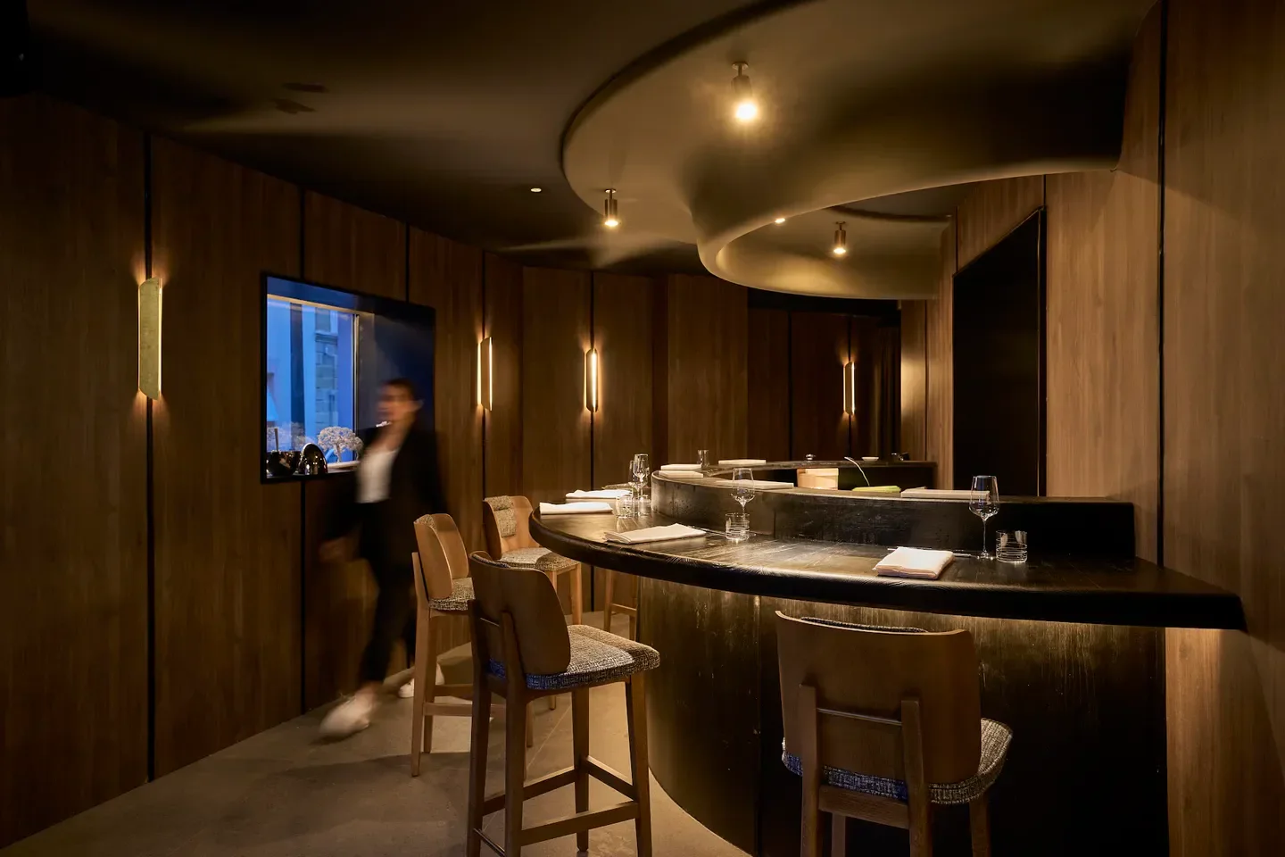 Interior of Toki in Madrid, showcasing its stylish design with wood paneling and lighting.