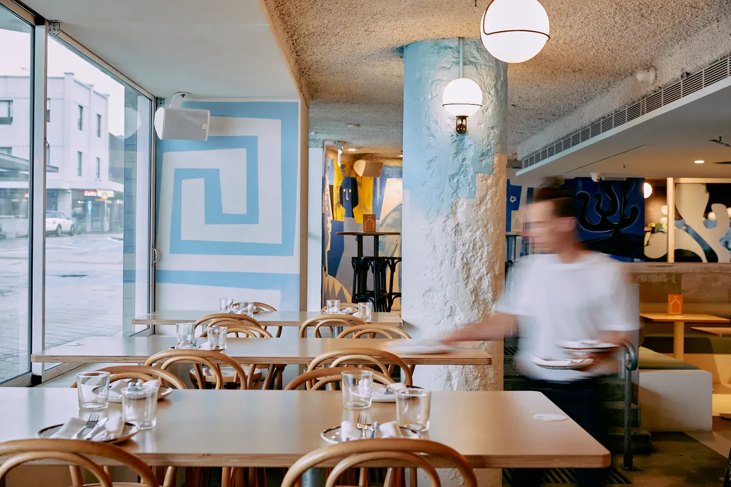 Interior of Topikós restaurant in Sydney with unique design and waiter in action.