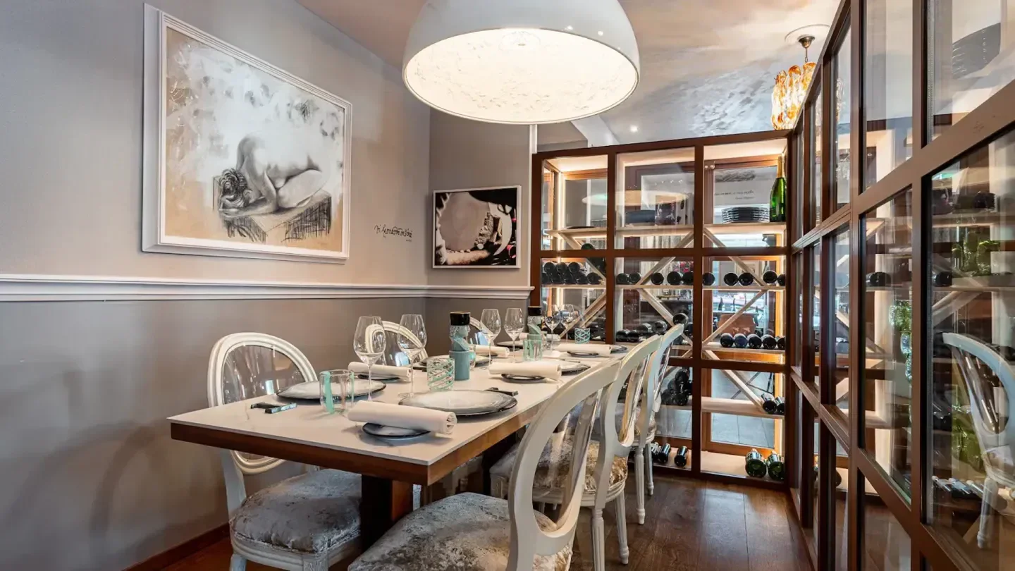 Elegant dining at Tosca restaurant in Geneva, with artwork and wine display.