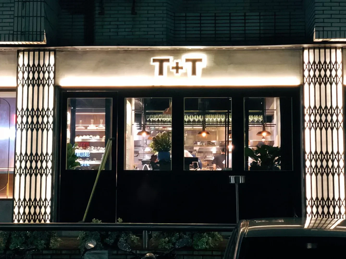 TT restaurant in Taipei at night, featuring a lit sign and window view.