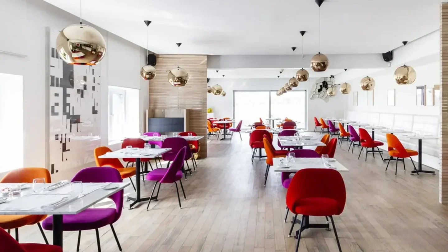 Interior of TWO6TWO restaurant in Luxembourg, with colorful chairs and modern decor.