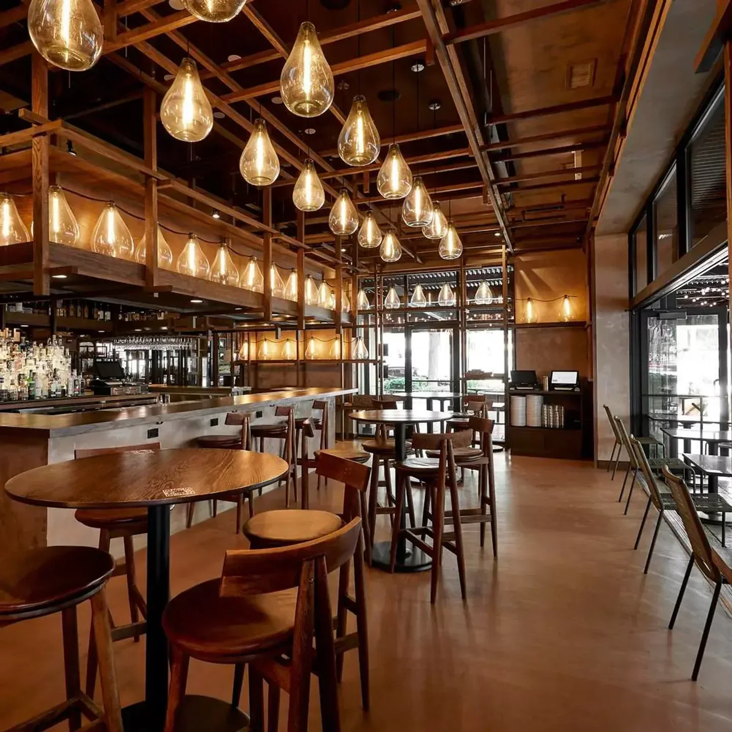 Interior view of Tzuco restaurant in Chicago, with wooden tables and decorative lighting.