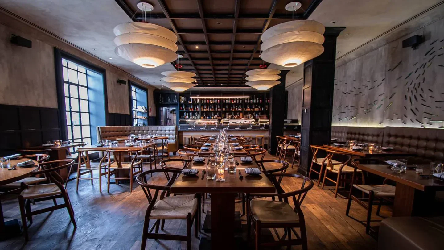 Elegant dining room interior at Uni restaurant in Boston, featuring stylish lighting and decor.