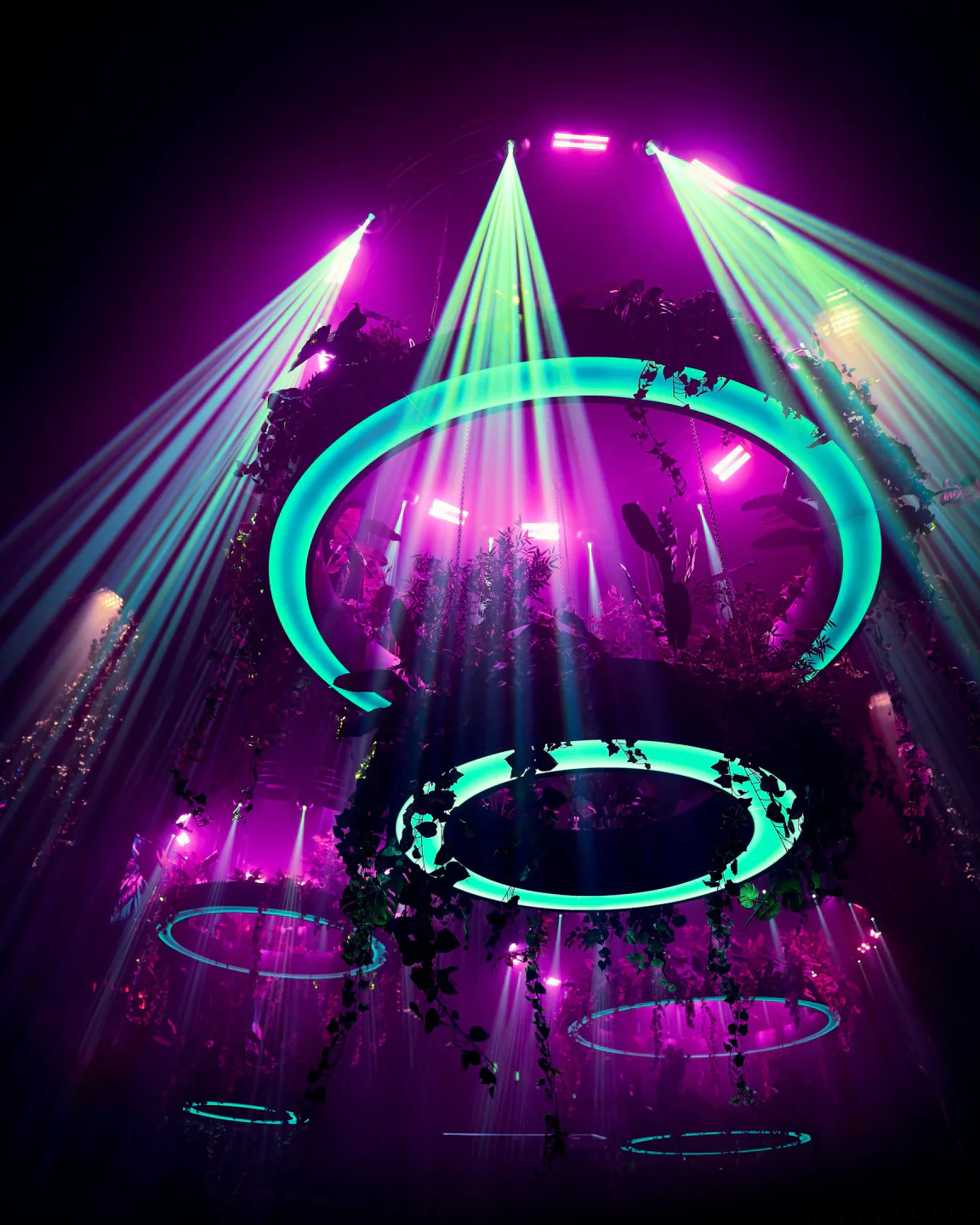 UNVRS nightclub in Ibiza features stunning ambiance with green ring lights and purple spotlights.