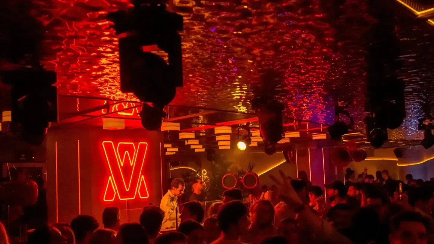 Inside Vandido nightclub in Madrid, with a red neon glow and a lively crowd.