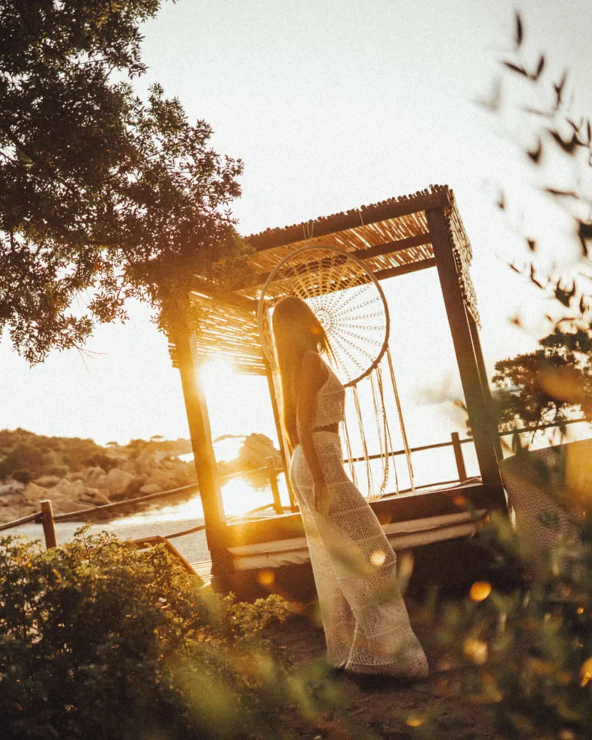Woman enjoying sunset at Vesper Beach Club in Porto Cervo, Sardinia, with a boho-chic cabana.