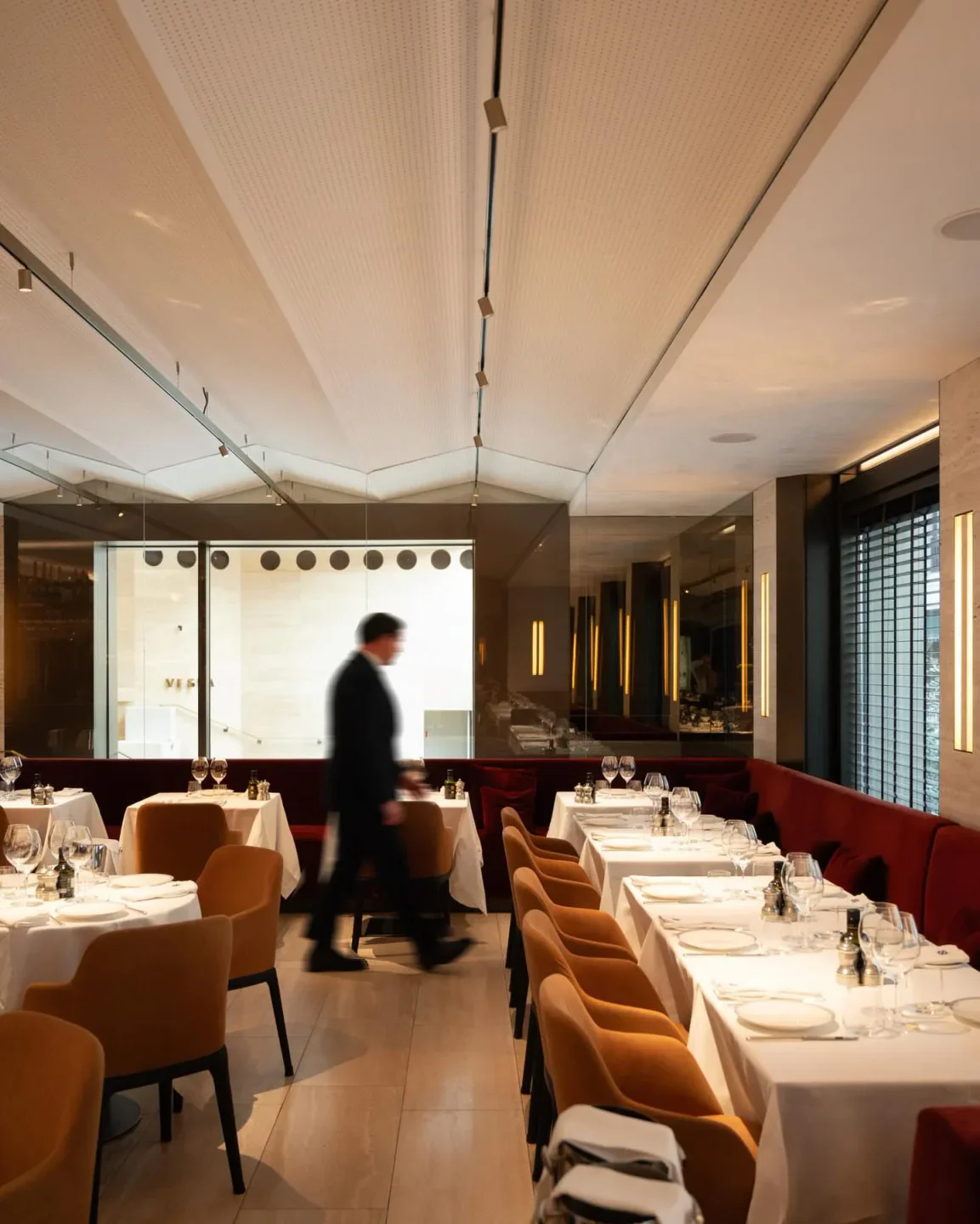 Vesta restaurant in Porto Cervo featuring elegant dining tables with white tablecloths and warm lighting.