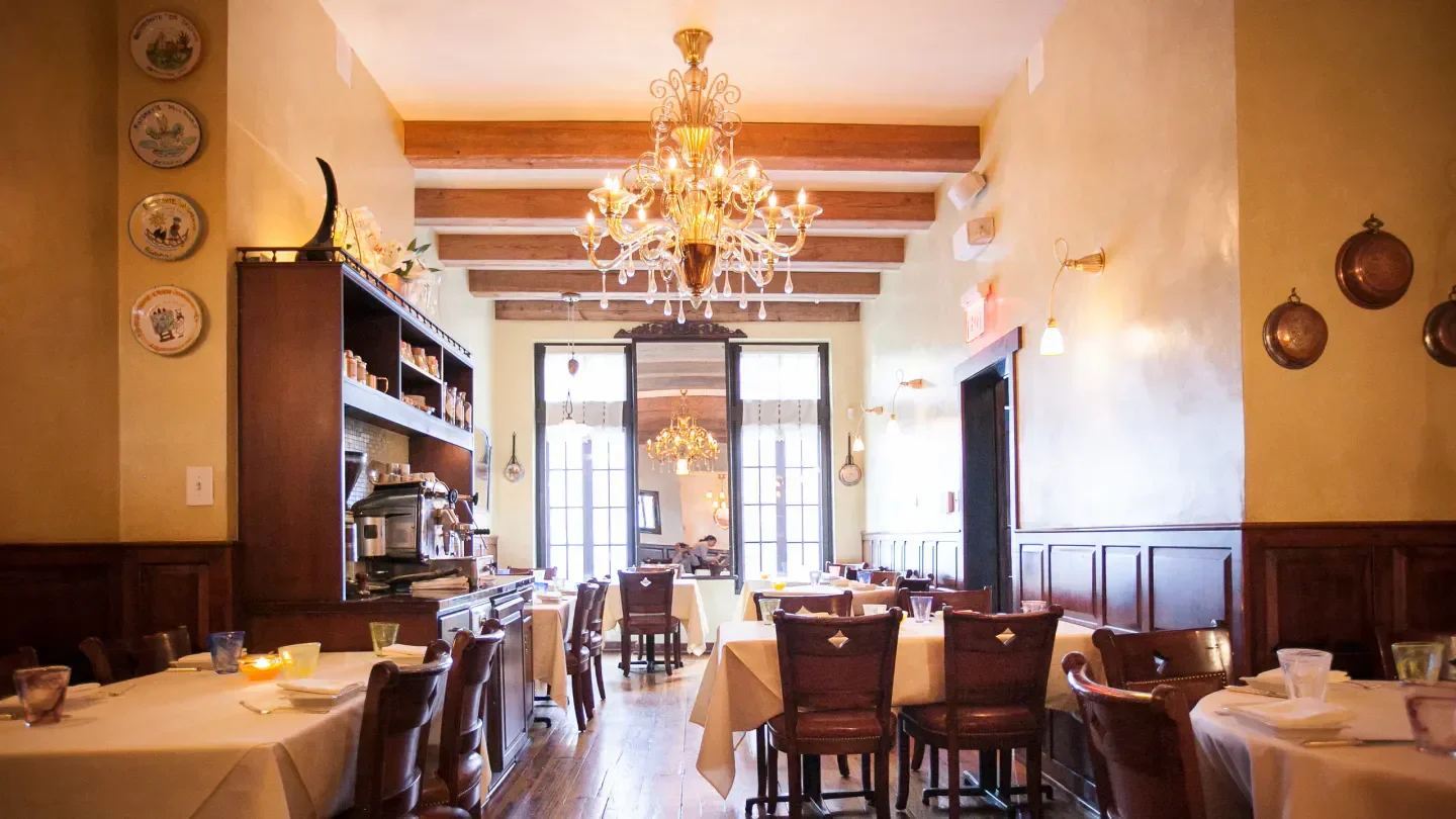 Elegant dining room interior at Vetri Cucina in Philadelphia with chandelier and tables.