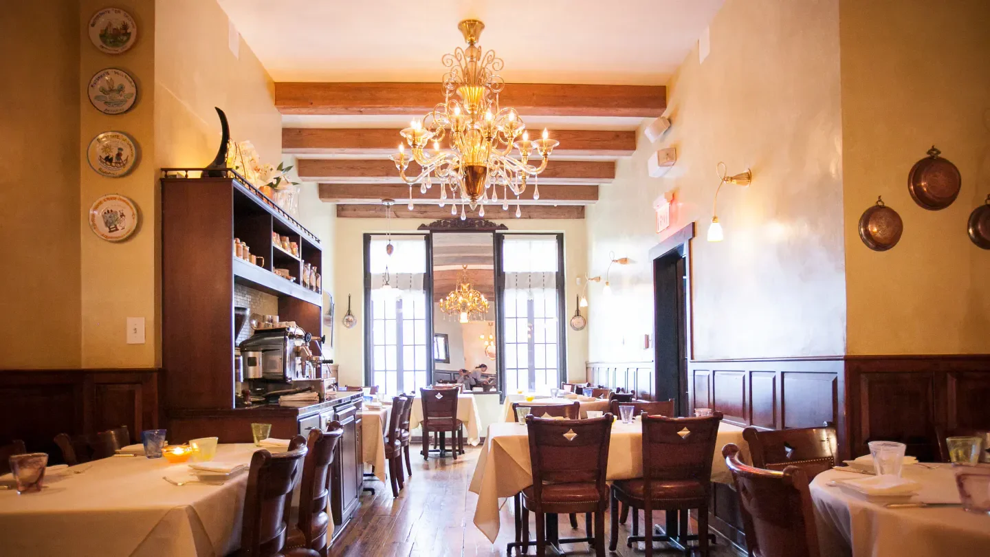 Elegant dining room interior at Vetri Cucina in Philadelphia with chandelier and tables.