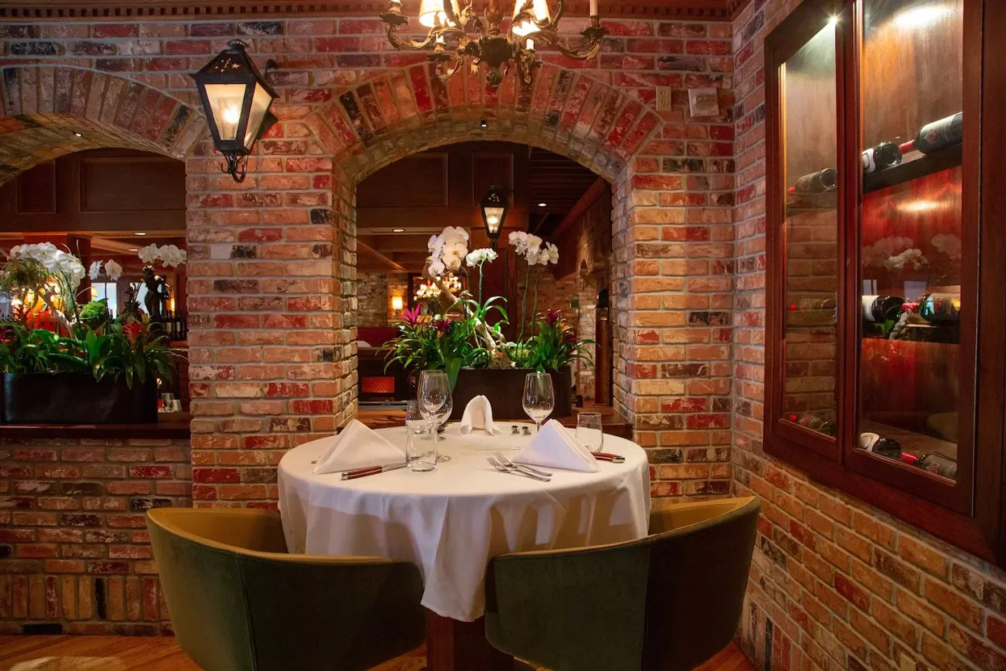 Cozy dining area at Vito's Chop House in Orlando, featuring a brick interior and table setting.