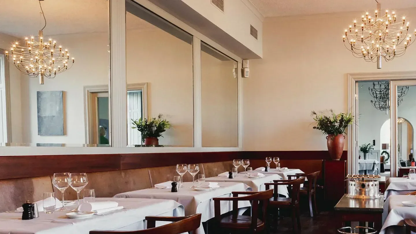 Elegant interior of Wedholms Fisk in Stockholm, featuring stylish chandeliers and dining tables.