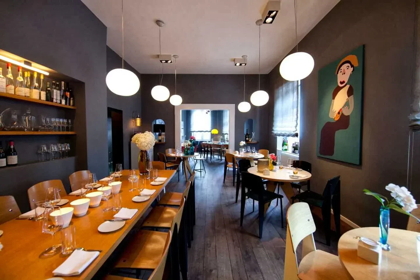 Elegant dining area at Weinsinn restaurant in Frankfurt, with stylish lighting and artwork.