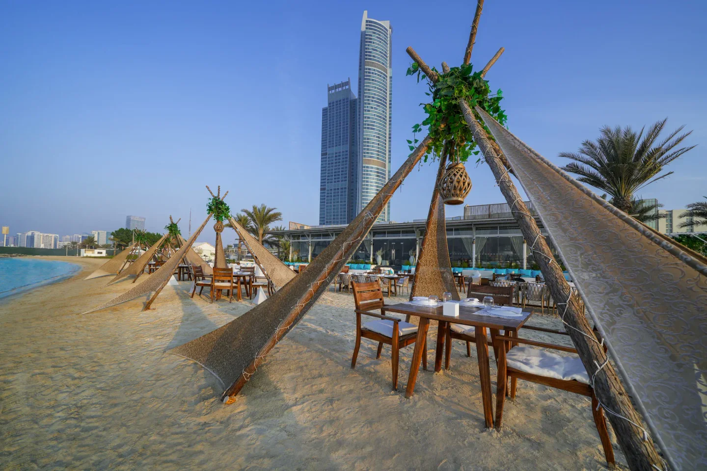 West Bay Lounge Abu Dhabi Corniche: beachfront dining with teepee-style canopies and city skyline views.