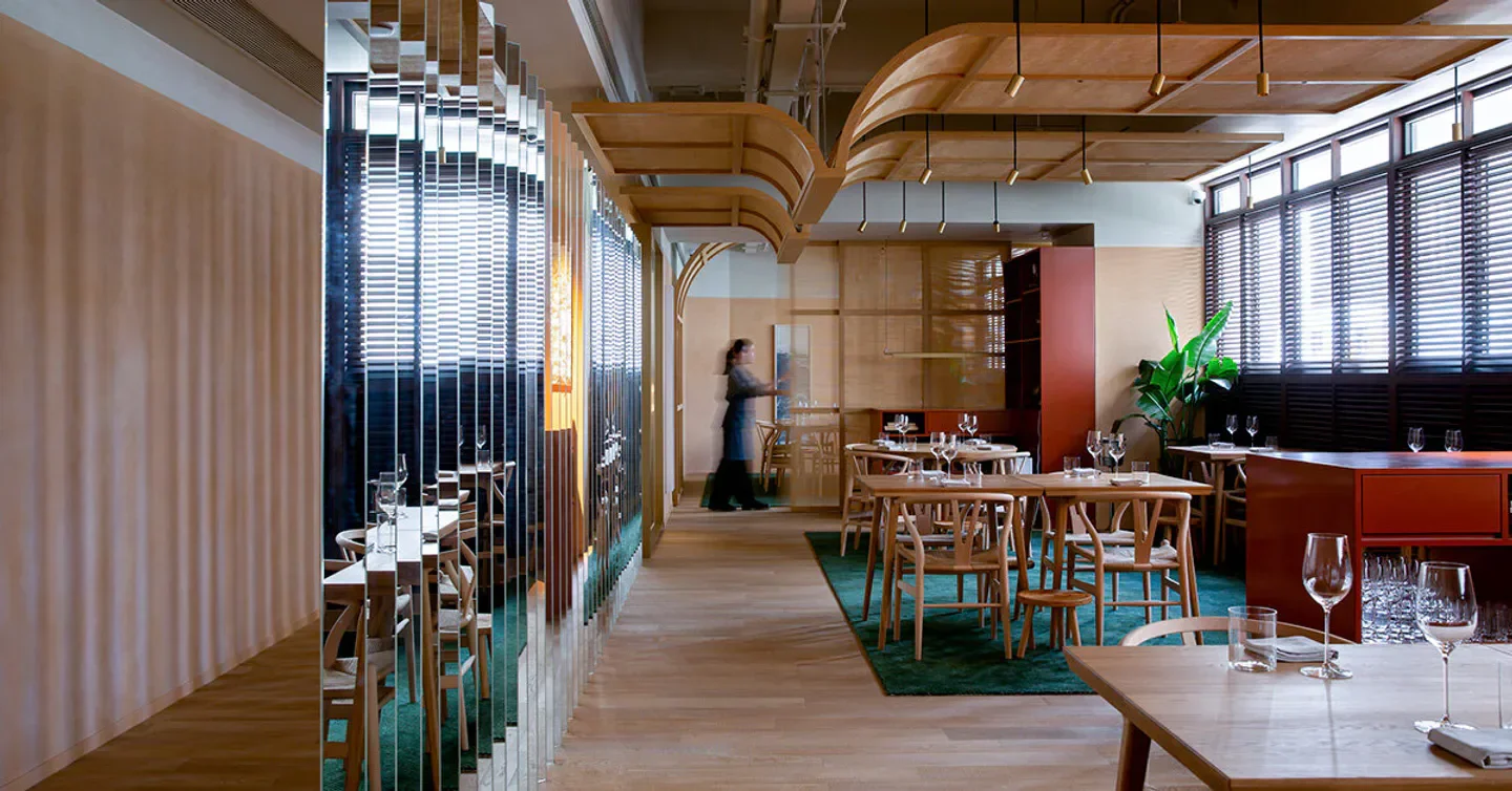 Interior of Whey restaurant in Hong Kong, featuring wooden tables and a modern design