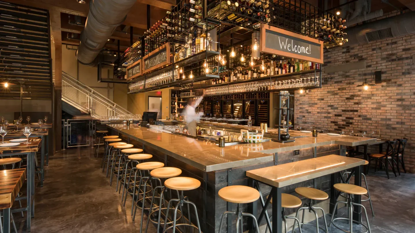 Interior of Wine Bar George in Orlando, featuring a stylish bar with stools and welcoming ambiance.