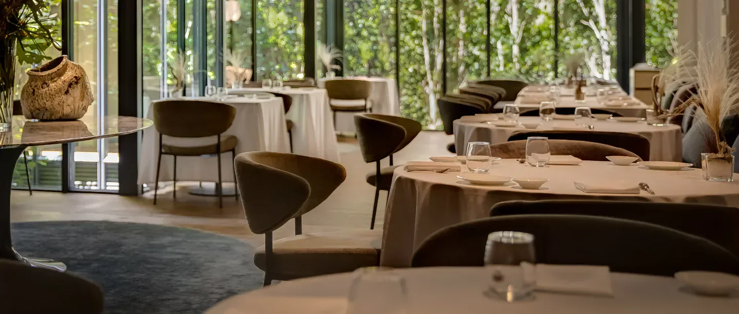 Elegant dining room interior at Xerta restaurant in Barcelona, with round tables