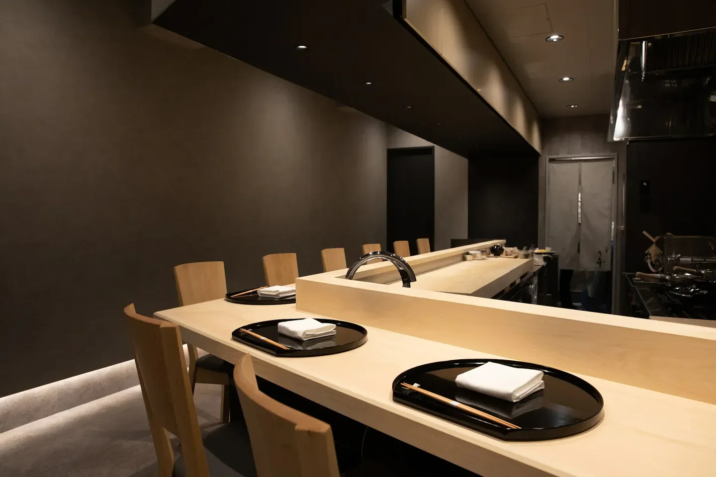 Interior of Yakumo Uezu restaurant in Tokyo, featuring stylish wooden details and ambiance.