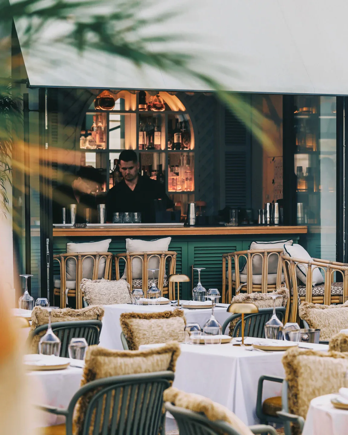 Stylish interior of Zellij nightclub with elegantly set tables and a bartender behind the bar.