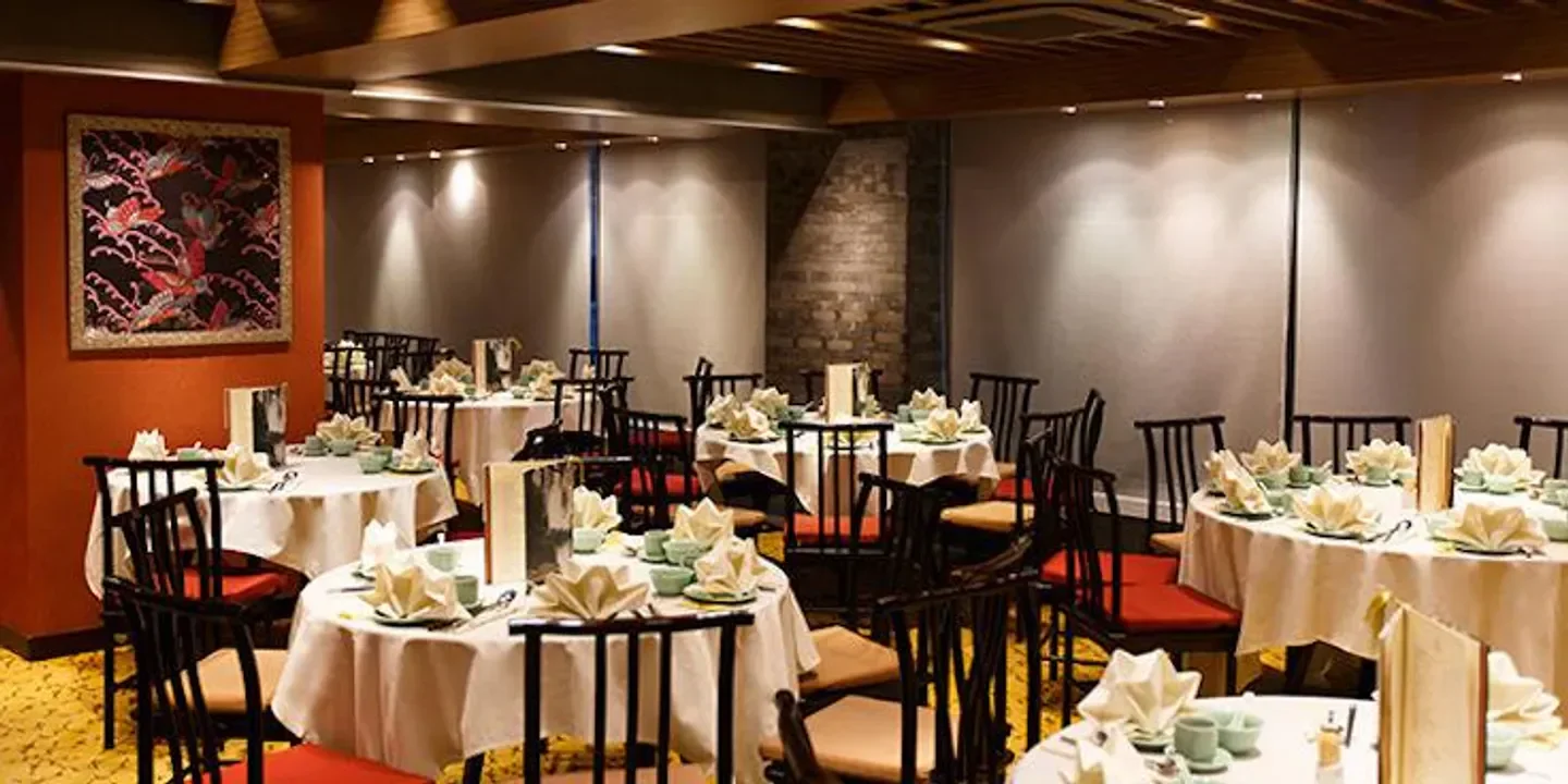 Elegant dining room at Zhejiang Heen restaurant in Hong Kong, with round tables.