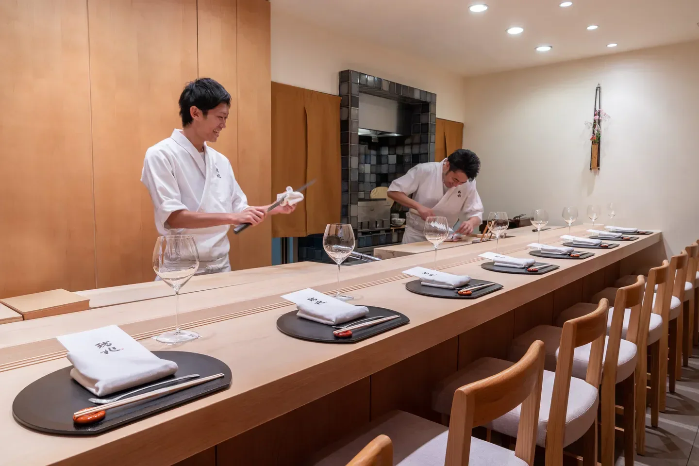 Chefs preparing food at Zuicho restaurant in Hong Kong, with elegant dining area