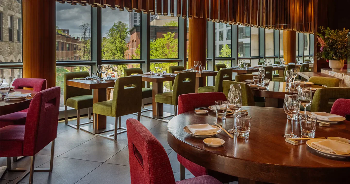 Interior of Zuma Boston restaurant with tables set for dining and city views